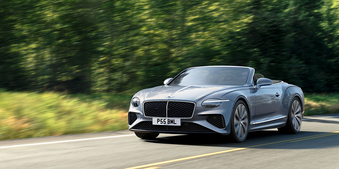 Bentley Birmingham New Bentley Continental GTC convertible front view in Silverlake paint with 22 inch ten spoke wheels, driving dynamically on a country road