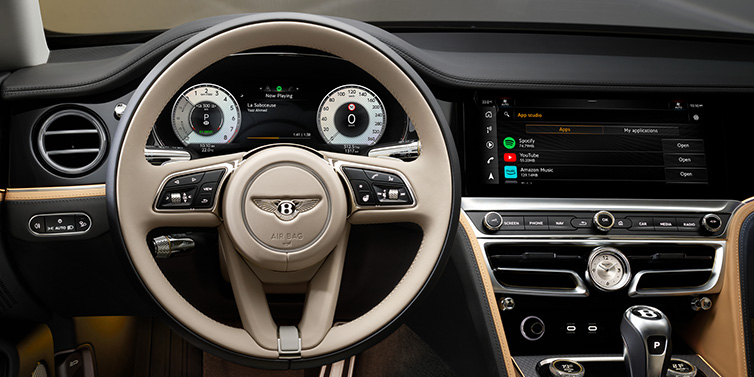 Bentley Birmingham Bentley Flying Spur Mulliner sedan front interior detail of steering wheel and driver screens surrounded by Linen and Beluga black hides