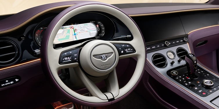 Bentley Birmingham Bentley Continental GT Mulliner coupe front interior showing steering wheel and drivers screens surrounded by Linen and Damson hides and Grand Black veneer